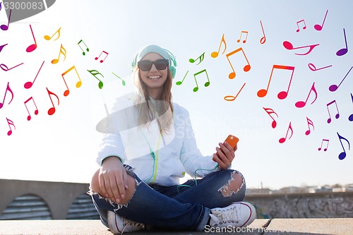 Image of happy young woman with smartphone and headphones