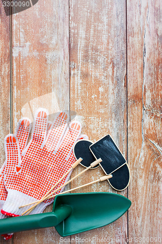 Image of close up of trowel, nameplates and garden gloves