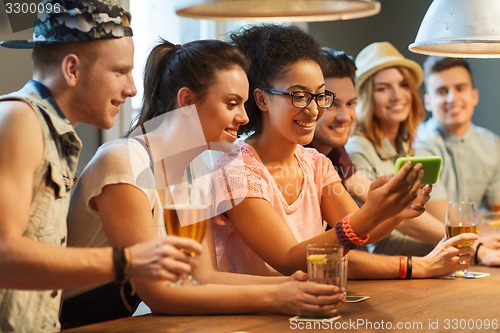 Image of happy friends with smartphone taking selfie at bar