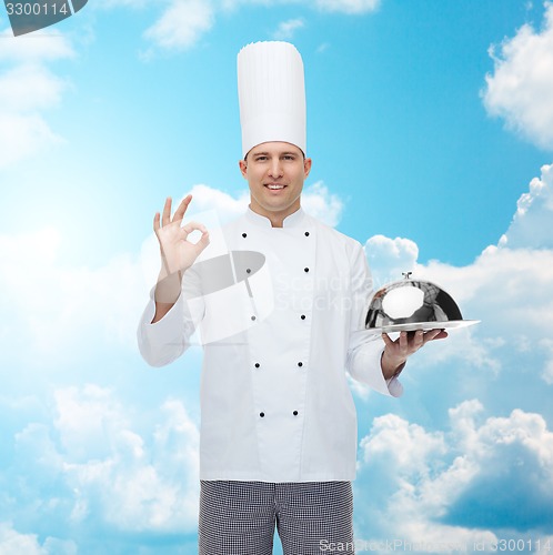 Image of happy male chef cook with cloche showing ok sign