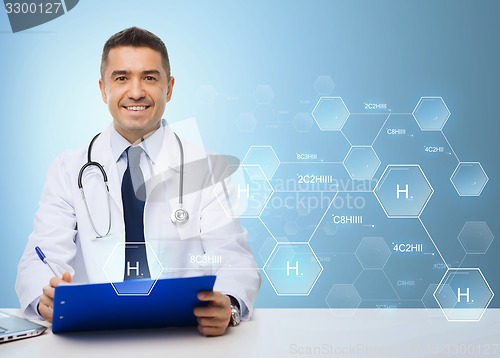 Image of happy doctor with clipboard over blue background