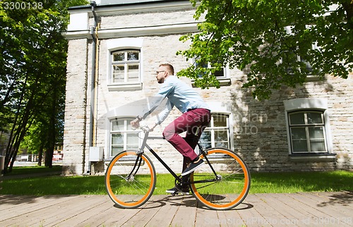 Image of happy young hipster man riding fixed gear bike