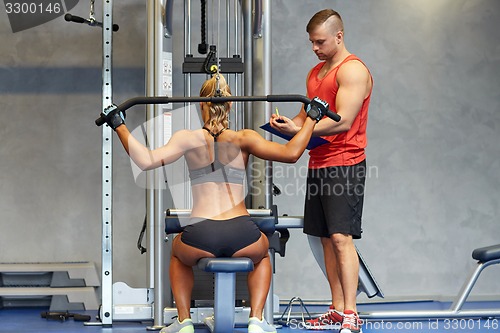 Image of man and woman flexing muscles on gym machine