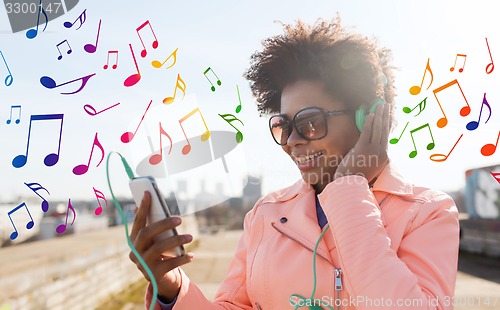 Image of happy young woman with smartphone and headphones