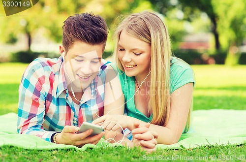 Image of smiling couple with smartphone and earphones