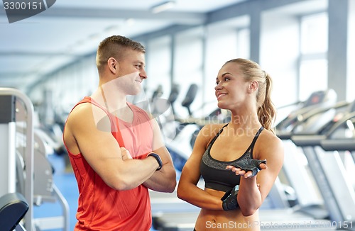 Image of smiling man and woman talking in gym