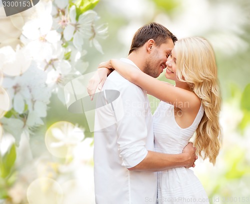 Image of happy couple hugging over blooming summer garden