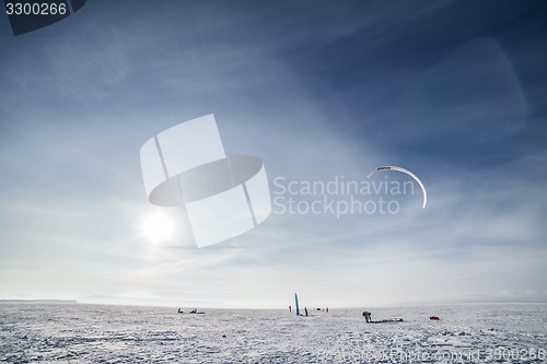 Image of Kiteboarder with blue kite on the snow