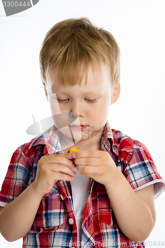 Image of Little boy standing with toy. studio