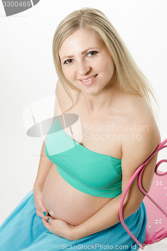 Image of pregnant young woman hugging belly