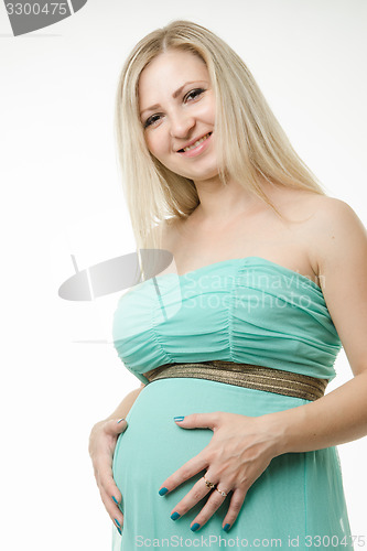 Image of Portrait of a pregnant young girl hugging belly