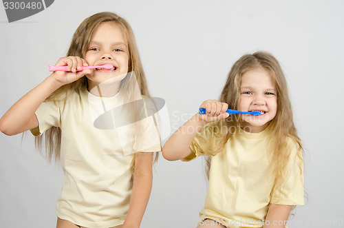 Image of Two sisters brushing their teeth