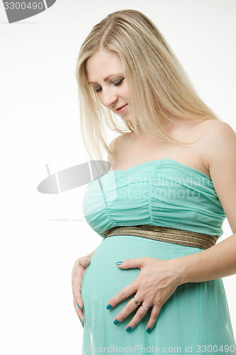 Image of Portrait of a pregnant woman is looking at the stomach