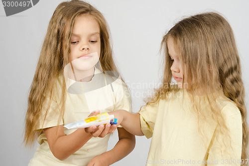 Image of Girl squeezing toothpaste from a tube sister