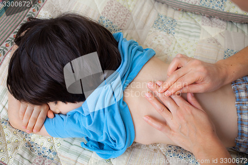 Image of doctor therapists taps the back of a young patient