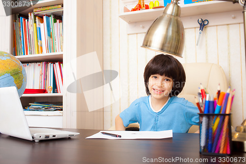 Image of smiling schoolboy doing homework