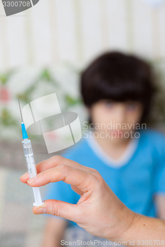 Image of Doctor hand with syringe and child