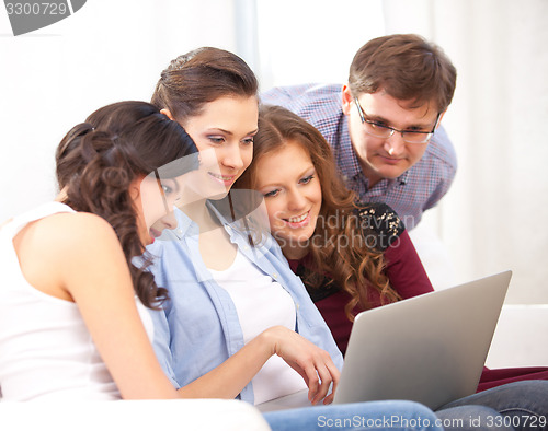 Image of four students and a laptop
