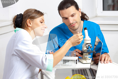 Image of two researchers are looking at a test tube