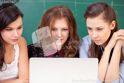 Image of Three students and a notebook