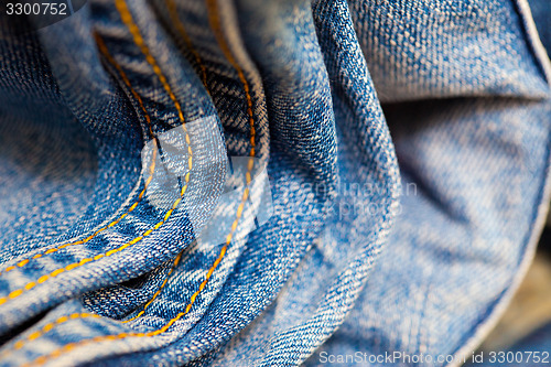 Image of aged Jeans with yellow stitching thread