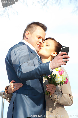 Image of beautiful bride and groom make selfie