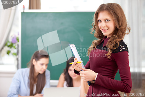 Image of smiling pretty girl looking at camera in college