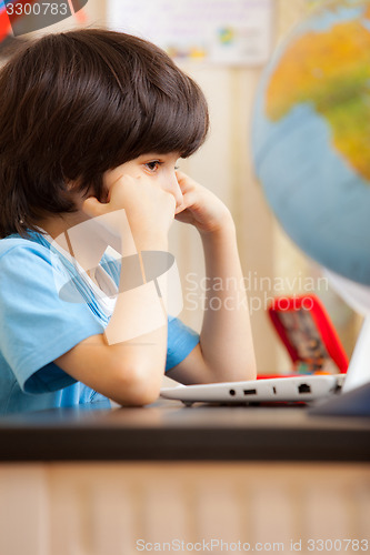 Image of pensive boy sitting at a table