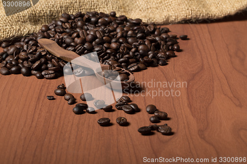 Image of pile of fresh and bio aromatic coffee beans and spoon