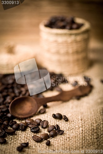 Image of pile of fresh and bio aromatic coffee beans and spoon