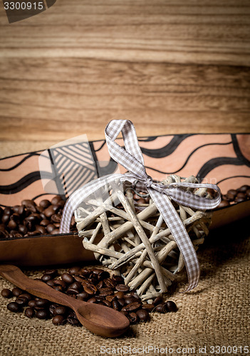 Image of pile of fresh coffee beans, heart and spoon