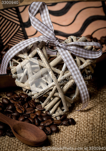 Image of pile of fresh coffee beans, heart and spoon