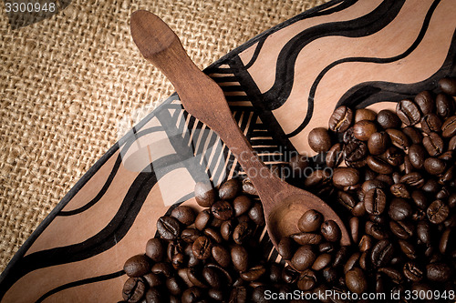 Image of pile of fresh and bio aromatic coffee beans and spoon