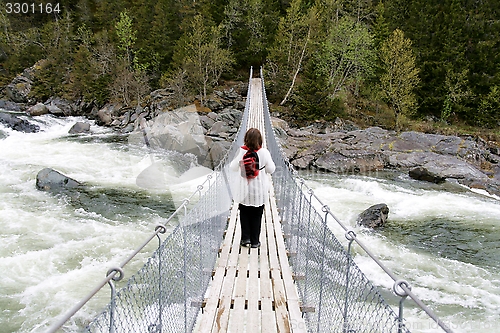Image of Woman on suspension bridge