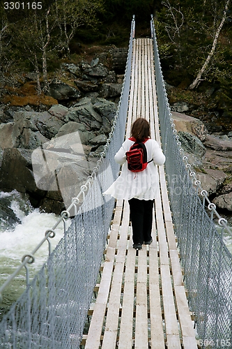 Image of Woman on a suspension bridge