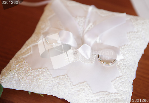Image of Wedding rings on embroidered pillow