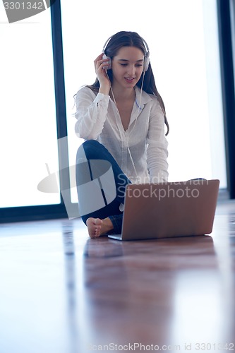 Image of relaxed young woman at home working on laptop computer