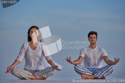 Image of young couple practicing yoga