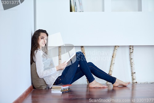 Image of relaxed young woman at home working on laptop computer