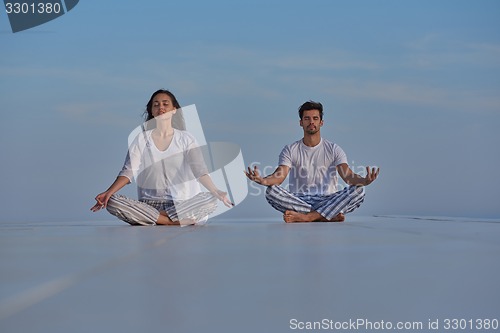 Image of young couple practicing yoga