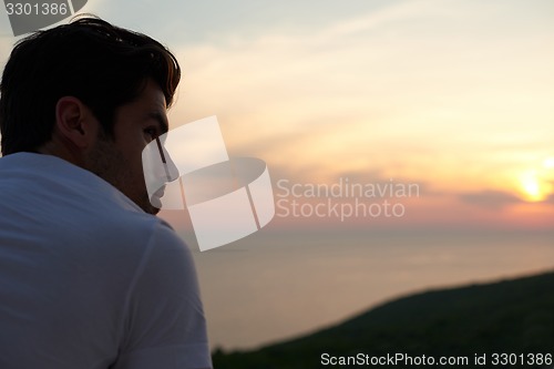 Image of relaxed young man at home on balcony