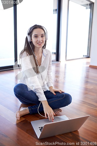 Image of relaxed young woman at home working on laptop computer