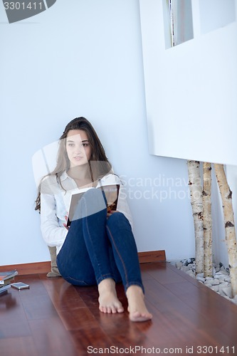 Image of relaxed young woman at home working on laptop computer