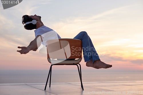 Image of relaxed young man at home on balcony