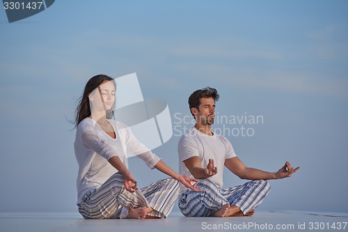 Image of young couple practicing yoga