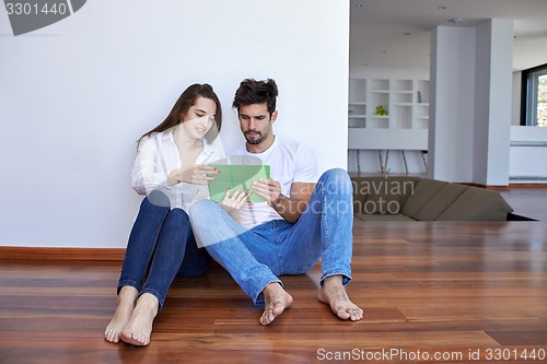 Image of couple at modern home using tablet computer