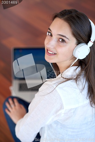 Image of relaxed young woman at home working on laptop computer