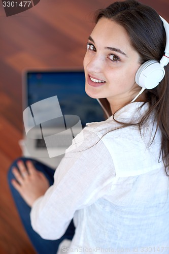Image of relaxed young woman at home working on laptop computer