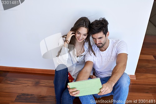 Image of couple at modern home using tablet computer