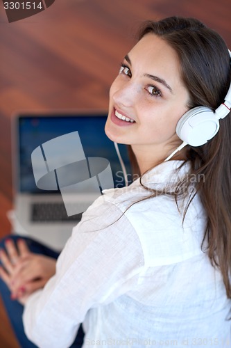Image of relaxed young woman at home working on laptop computer